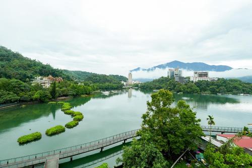 a river in a city with trees and buildings at Zhaohong homestay in Yuchi