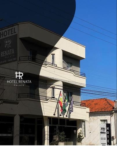 a hotel building with flags in front of it at Hotel Renata Tubarão in Tubarão