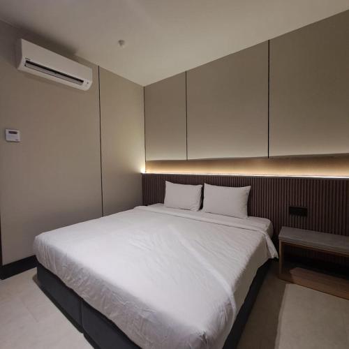 a bedroom with a large bed with white sheets at Urban Inn, Myra Meranti in Cyberjaya
