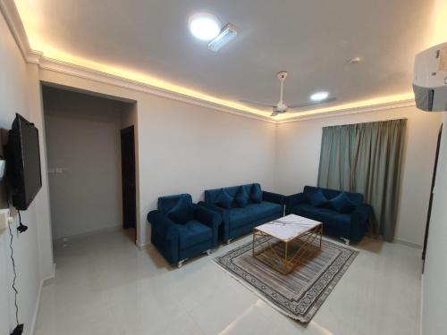 a living room with blue couches and a table at aswar gulf in Salalah