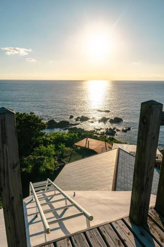 a view of the ocean from a building with a chair at Takahira Base in Yakushima