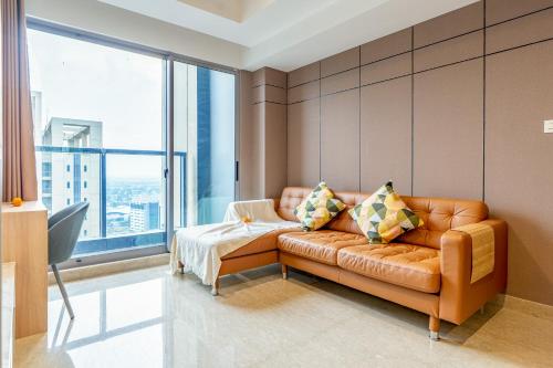 a living room with a couch and a large window at Branz Apartement BSD City by Nagisa Bali in Kramat