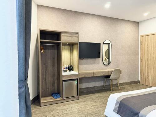 a bedroom with a bed and a desk and a television at LION 6 HOTEL in Can Tho