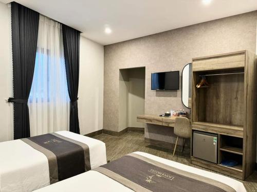 a hotel room with two beds and a desk at LION 6 HOTEL in Can Tho