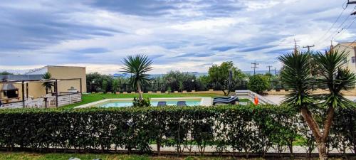 a villa with a swimming pool and palm trees at Catamaran Corfu Aparthotel in Acharavi