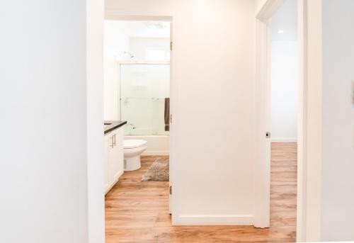 a white bathroom with a toilet and a sink at Sleek 1-Bedroom Apartment with AC & gated Parking space in Los Angeles