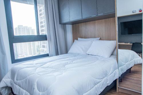 a bedroom with a large white bed in front of a window at ST Studios Vila Mariana by Housi in Sao Paulo