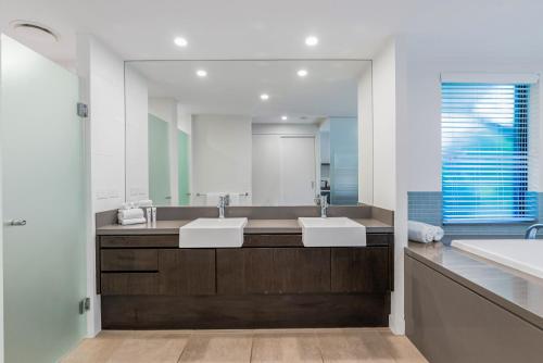 a bathroom with two sinks and a large mirror at Resort-style Swim Out - A Poolside Oasis in Port Douglas