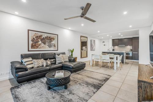 a living room with a couch and a table at Resort-style Swim Out - A Poolside Oasis in Port Douglas