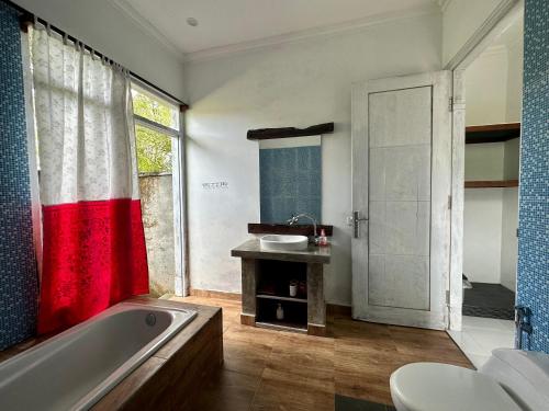 a bathroom with a tub and a sink and a shower at The Winaposa in Munduk