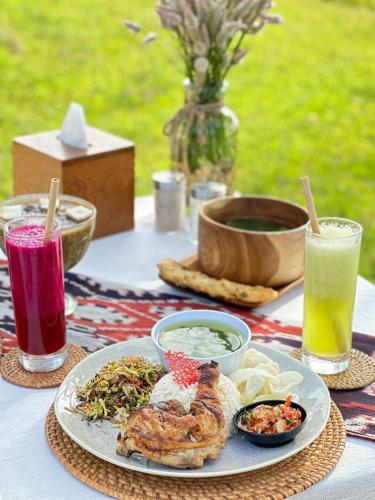 a table with a plate of food and two drinks at Morika Villa in Rua