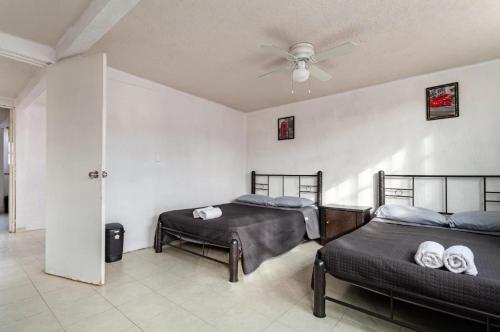 a bedroom with two beds and a ceiling fan at KingsLanding in Morelos