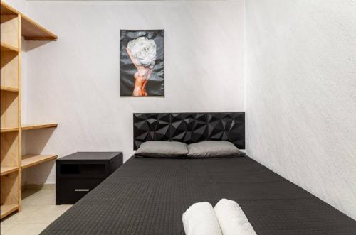 a room with a bed with a black head board at KingsLanding in Morelos