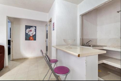 a kitchen with two chairs and a counter with a sink at KingsLanding in Morelos