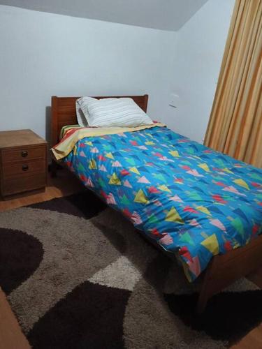 a bedroom with a bed with a blue comforter at Hermosa casa central en Chillán in Chillán