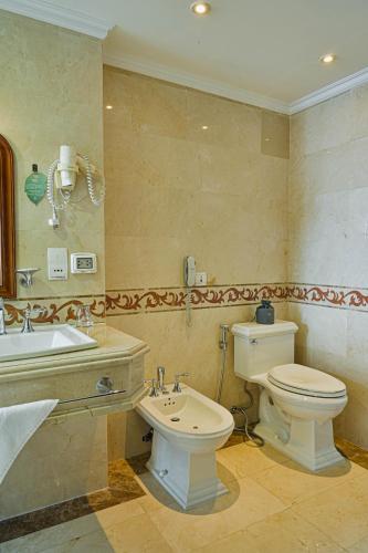 a bathroom with a toilet and a sink at Hotel Grand Saigon in Ho Chi Minh City