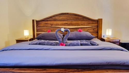 a bed with two stuffed animals on top of it at Ananda B&B in Gili Air