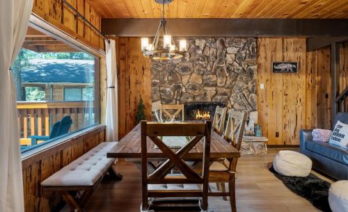 ein Wohnzimmer mit einem Tisch und einer Steinmauer in der Unterkunft Cozy Cabin near Resorts and The Village +Mtn views in Big Bear City