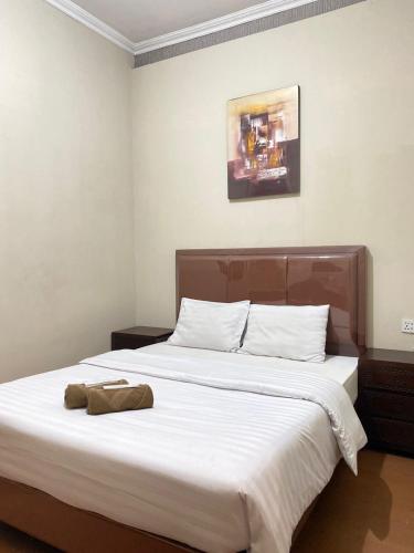 a bedroom with a large bed with white sheets at Ayuri Hotel Malioboro in Sentool