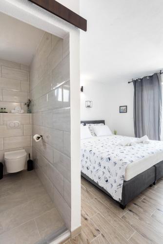 a white bedroom with a bed and a bathroom at Angeli Del Mare in Marusici 