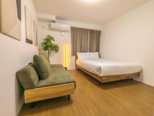 東京にあるSunRise STAY Nakano Sakaueのベッドと椅子のあるホテルの部屋