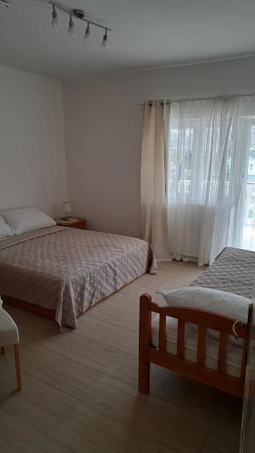 1 dormitorio con 2 camas y ventana en Apartman G&L en Grebaštica