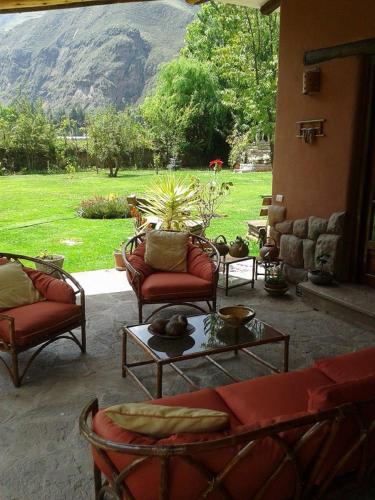 a patio with couches and a table with a view at Karina Wasi in Pisac