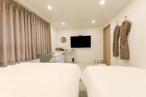 a hotel room with a bed and a tv at DAOR Hotel in Busan