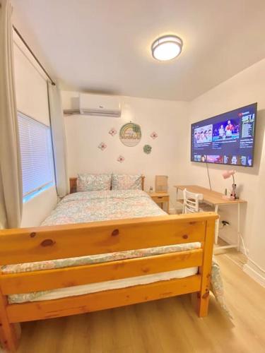 a bedroom with a bed and a television in it at Pink Cozy house 2 bedrooms in Rosemead
