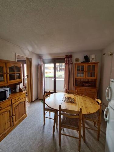 une cuisine avec une table en bois et un réfrigérateur dans l'établissement appartement montagne la vallée verte cœur station Hirmentaz, à Bellevaux