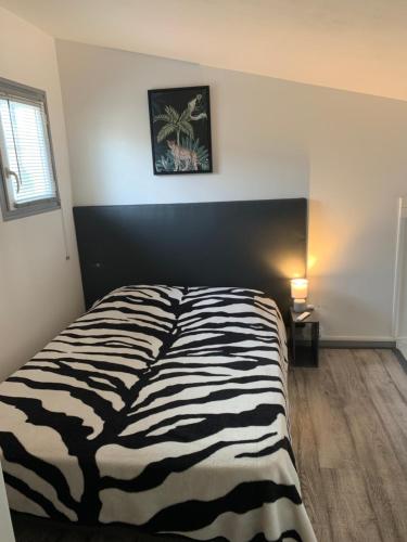 - un lit à motifs zébrés dans une chambre avec un mur dans l'établissement L appart d Ange 1 idéalement situe 37m2 entre port et village, à Gruissan