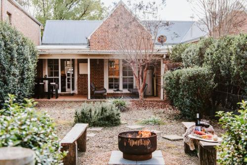 a backyard with a fire pit and a house at Kareela Cottage - A Charming Country Getaway in Mudgee