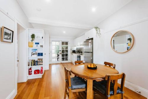 a kitchen and dining room with a wooden table and chairs at Kareela Cottage - A Charming Country Getaway in Mudgee