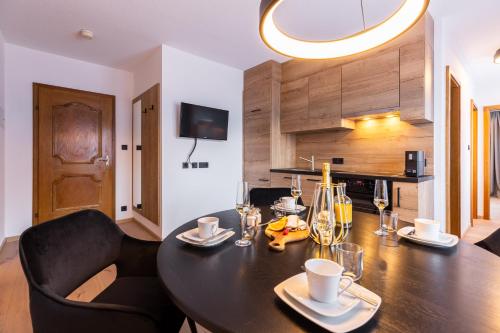 a dining room with a black table and chairs at Quality Hosts Arlberg - AFOCH FEI - das Landhaus in Sankt Anton am Arlberg