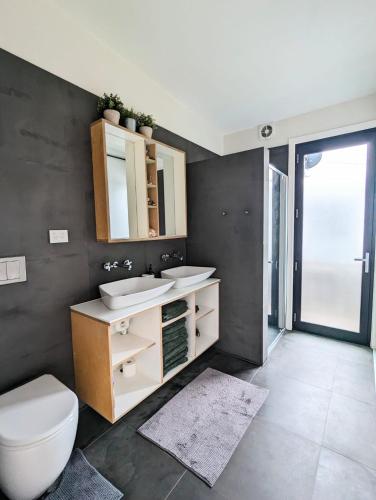 a bathroom with a toilet and a sink and a mirror at Kutu Ev in Apollo Bay