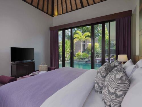 a bedroom with a large bed and a large window at The Ayu Kintamani Villa at Toya Devasya in Kintamani