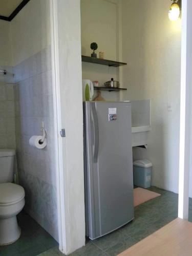 a small bathroom with a refrigerator and a toilet at Carcar Guesthouse in Barraca