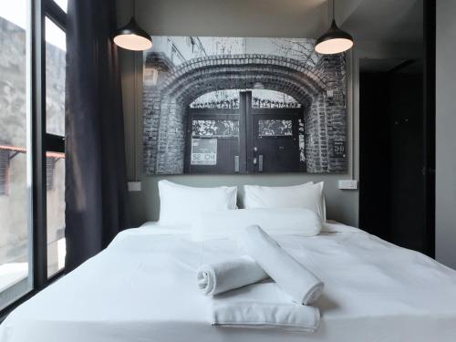 a large white bed with towels on top of it at Rucksack Inn Premium Melaka in Melaka