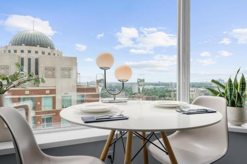 a white table and chairs in a room with a window at Downtown Toronto Condo with Gym & Subway Access in Toronto