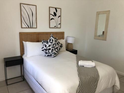 a bedroom with a large white bed with two pillows at Bluebanana Lodge in Mthatha