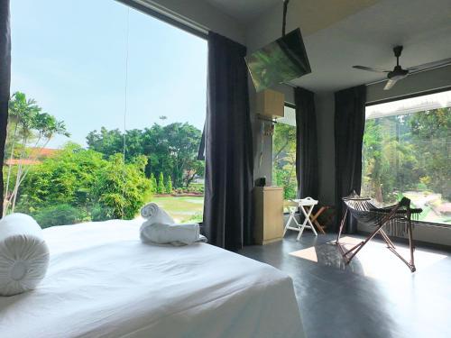 a bedroom with a large bed with a large window at Rucksack Inn Premium Melaka in Melaka