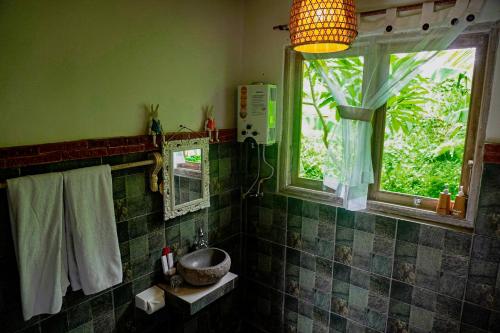 a bathroom with a sink and two windows at Kresna Asih House in Tampaksiring
