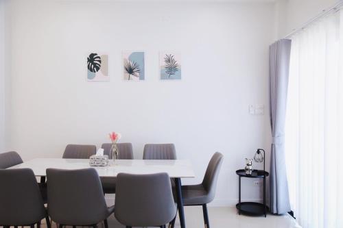 une salle à manger avec une table et des chaises blanches dans l'établissement Prime Stay Home Nan, à Nan