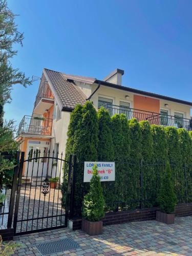 a house with a fence with a sign on it at Lorens Family in Mikołajki