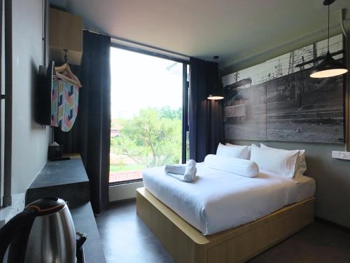 a bedroom with a large bed with a large window at Rucksack Inn Premium Melaka in Melaka