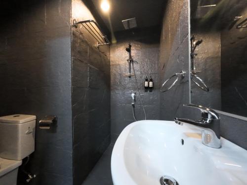 a bathroom with a white sink and a shower at Rucksack Inn Premium Melaka in Melaka