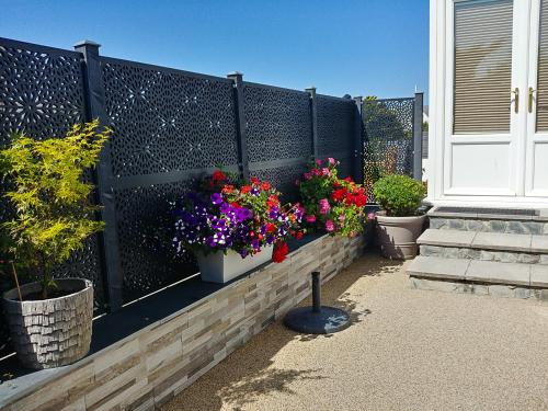 a fence with two pots of flowers on it at Meadow View Apartments in Newquay