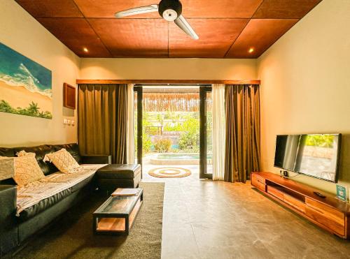 a living room with a couch and a flat screen tv at Private Pool Villa Retreat NAMU no4 no5 no6 in Kuta Lombok
