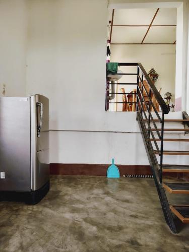 a room with a staircase and a refrigerator at Upasana Homestay in Dibrugarh