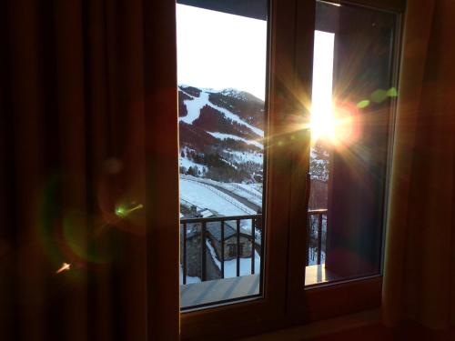 a window with a view of a snow covered mountain at Hotel Roc de St Miquel & Apartment in Soldeu